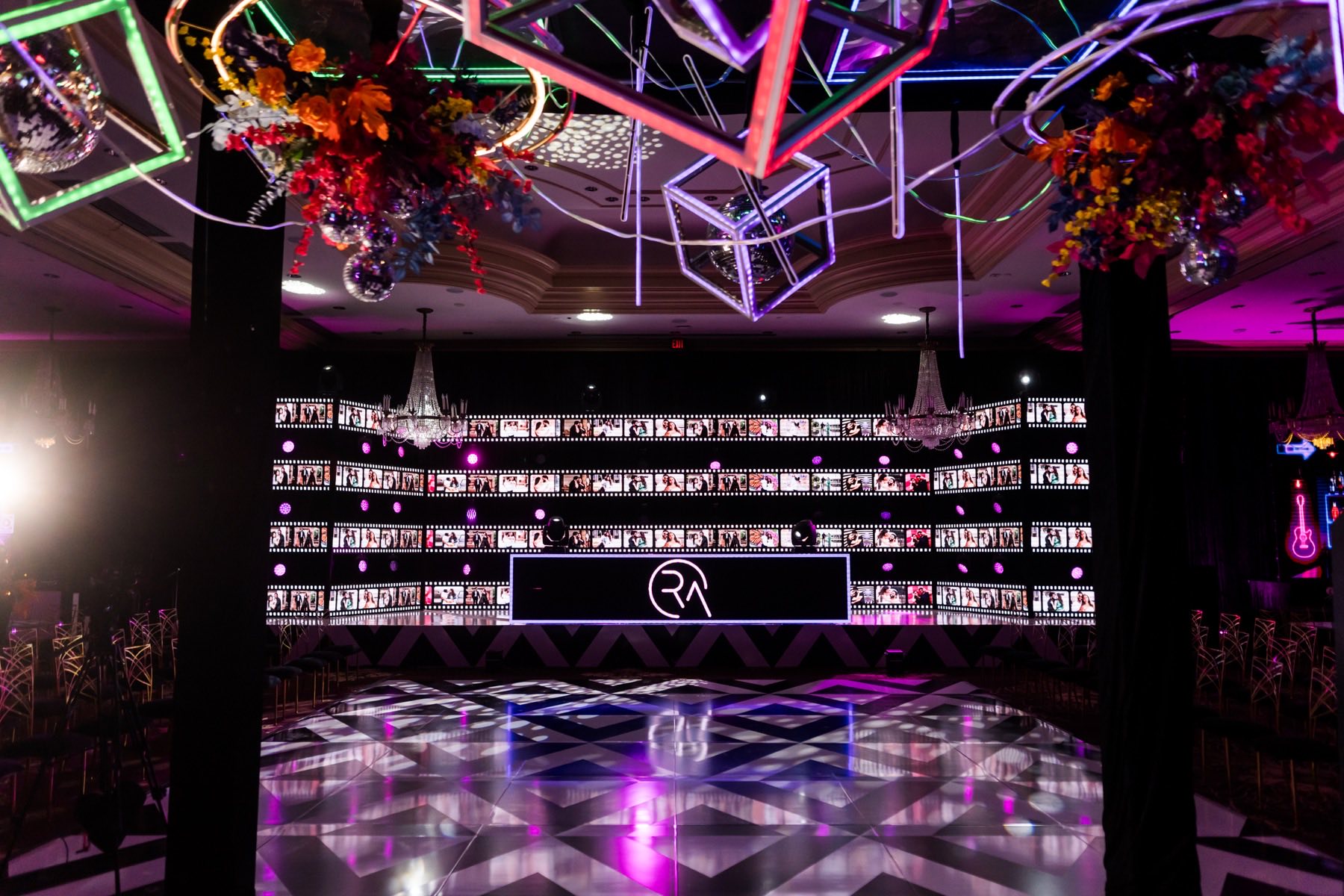 Modern sangeet stage with neon geometric art installations and photo backdrop wall